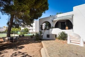 a white building with stairs and a table and chairs at Ca Nostra Ibiza in Sant Josep de sa Talaia