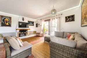 a living room with a couch and chairs and a tv at Ca Nostra Ibiza in Sant Josep de sa Talaia