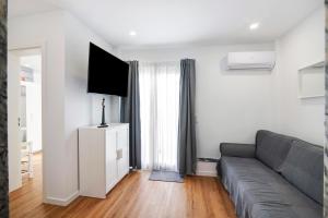 a living room with a gray couch and a television at Telmus Villa Rc D in Monte Gordo