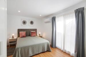 a bedroom with a bed and a large window at Telmus Villa Rc D in Monte Gordo