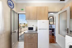 a kitchen with a refrigerator and a microwave at Casa Da Jesus in Provesende
