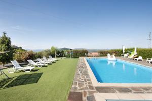a swimming pool with lounge chairs and a lawn at Casa Da Jesus in Provesende