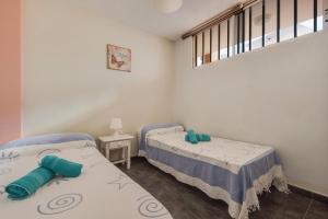 a bedroom with two beds and a window at Casa Caletillas in Candelaria