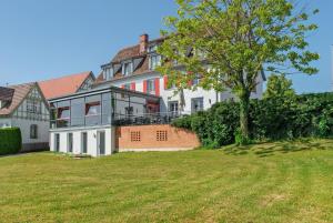 a large house with a tree in the yard at Altes Schulhaus in Heiligenberg