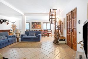 a living room with blue couches and a spiral staircase at La Torre in Arcola