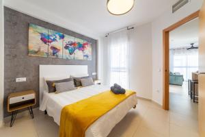 a bedroom with a large bed with a yellow blanket at Laguna beach Vera in Vera +20 photos