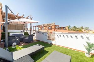 a rooftop patio with grass and an umbrella at Laguna beach Vera in Vera