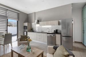 a kitchen and living room with a couch and a table at Urban Park Aloe in Los Llanos de Aridane