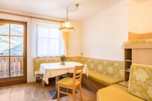 a dining room with a table and a couch at Kuglerhof Apt 2 in Cadipietra