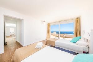 two beds in a hotel room with a view of the ocean at Villa Domus Alba A - B in Felanitx +36 photos