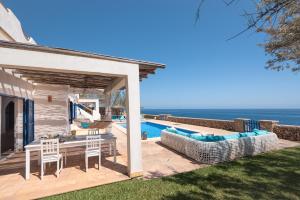 a patio with a table and chairs and a swimming pool at Villa Domus Alba A - B in Felanitx