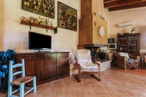 a living room with a flat screen tv and chairs at Casa Serra in Pimentel