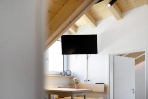 a living room with a table and a tv on the wall at Ferienwohnung Wendelsteinblick in Bad Tölz