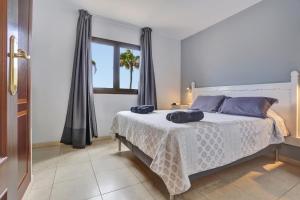 a bedroom with a bed with blue pillows on it at Oasis Royal F306 in Corralejo
