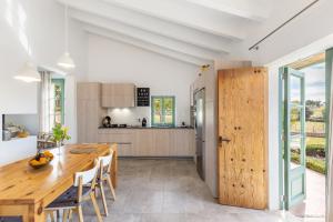 a kitchen and dining room with a wooden table and chairs at Sa Verdal in El Port de la Selva