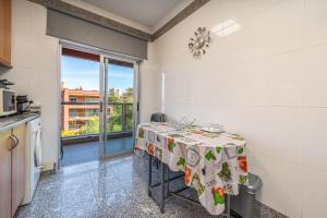 a small kitchen with a table and a window at Paraíso da Rocha in Portimão