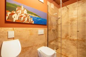 a bathroom with a toilet and a painting on the wall at Studio am Schloßteich in Chemnitz +17 photos