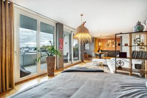 a bedroom with a large bed and large windows at Studio am Schloßteich in Chemnitz