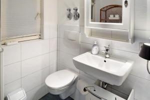 a white bathroom with a toilet and a sink at Ferienwohnung Gill in Staufen im Breisgau +18 photos
