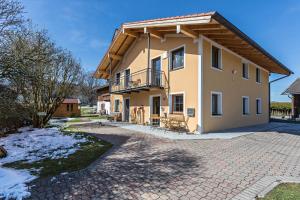 a house with a balcony on a brick driveway at Ferienwohnung Rupertiwinkl in Teisendorf