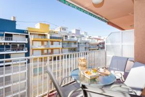 a table and chairs on a balcony with a view of a city at Palmera Beach House in Cullera