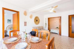 a dining room with a table and chairs at Palmera Beach House in Cullera