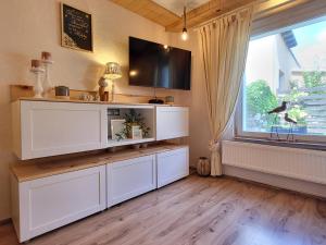 a living room with a large white entertainment center at Mien lüttes Glück -Fewo Backboord in Zempin +5 photos