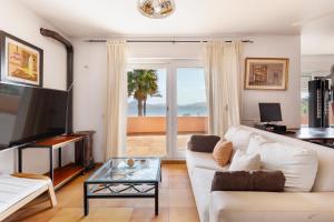 a living room with a white couch and a tv at La Gola in La Manga del Mar Menor