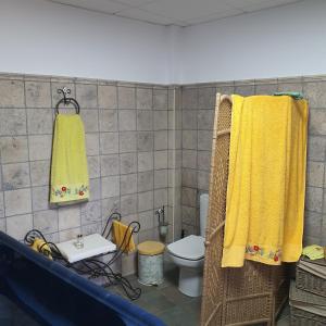 a bathroom with a toilet and yellow towels at Cueva de Manuel in Guadix