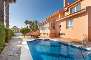 a villa with a swimming pool in front of a house at La Gola in La Manga del Mar Menor