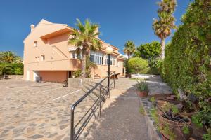 a house with palm trees in front of it at La Gola in La Manga del Mar Menor