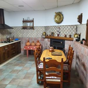 a kitchen with a table and chairs and a stove at Cueva de Manuel in Guadix