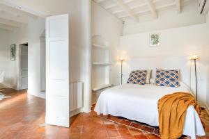 a bedroom with a white bed and a red tile floor at Villa Torret 46 in Sant Lluis +13 photos