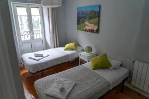 a room with two beds and a window at Apartamento luminoso y espacioso en Urdaibai in Elanchove
