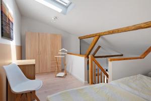 a bedroom with a bed and a white chair at Ferienwohnung Junge 1 in Lohe-Rickelshof