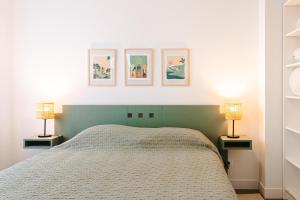 a bedroom with a bed and two lamps on tables at La Plage, Rivedoux Beach House in Rivedoux-Plage