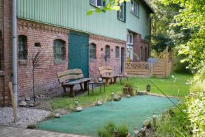 a garden with two benches and a brick building at Ferienwohnung Junge 1 in Lohe-Rickelshof