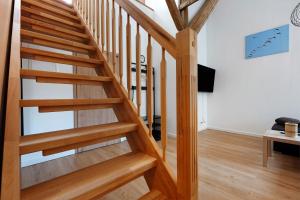 a wooden staircase in a living room with wooden floors at Ferienwohnung Junge 1 in Lohe-Rickelshof