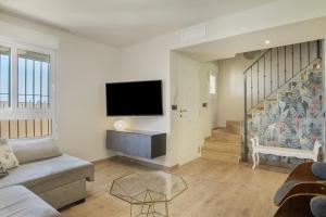 a living room with a couch and a flat screen tv at Luxury Tarifa in Tarifa