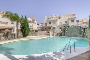 a large swimming pool with buildings in the background at Luxury Tarifa in Tarifa