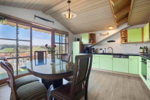 a kitchen with a table with chairs and a view at Weitsicht in Weiler-Simmerberg