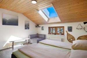 a bedroom with two beds and a skylight at Weitsicht in Weiler-Simmerberg