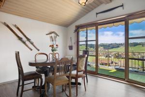 a dining room with a table and chairs and a large window at Weitsicht in Weiler-Simmerberg