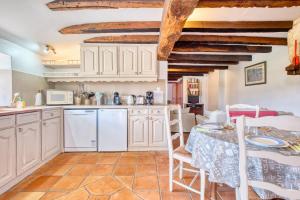 a kitchen with white cabinets and a table and chairs at Le Chai in Razac-dʼEymet