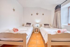 two twin beds in a room with a window at Le Chai in Razac-dʼEymet