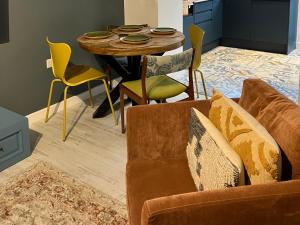a living room with a couch and a table and chairs at East meets West in Criccieth