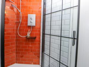 a shower with a red and white brick wall at East meets West in Criccieth +20 photos