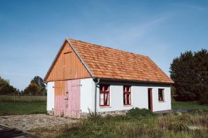 a small white house with an orange roof at Projektraum Obst und Sterne in Rensow