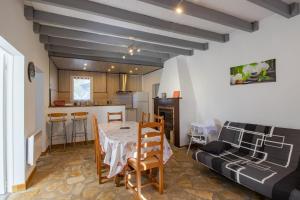 a kitchen and dining room with a table and a couch at Gite La Salamandre in Saint-André-dʼAllas