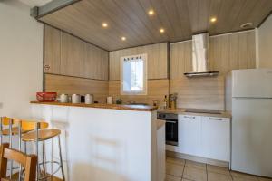 a kitchen with a white refrigerator and wooden cabinets at Gite La Salamandre in Saint-André-dʼAllas +20 photos